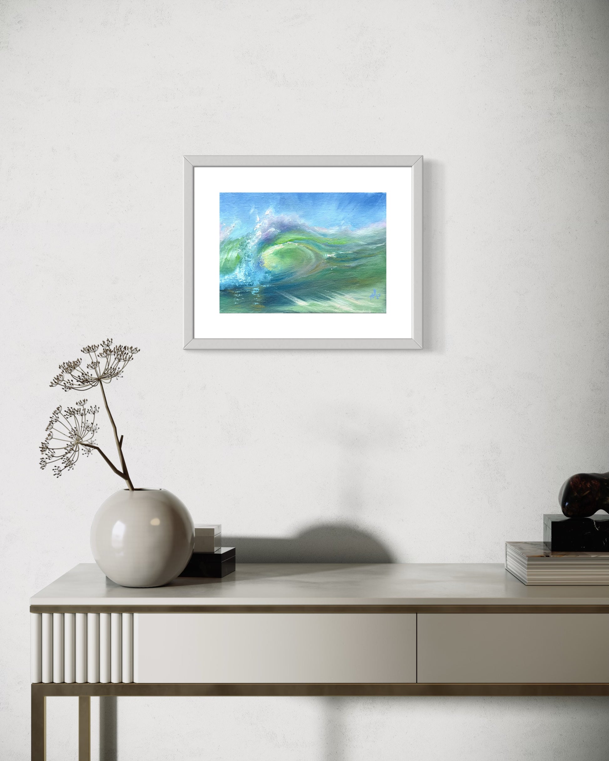 Miniature wave painting. Framed in white and silver frame, hanging on the wall above a vanity table.