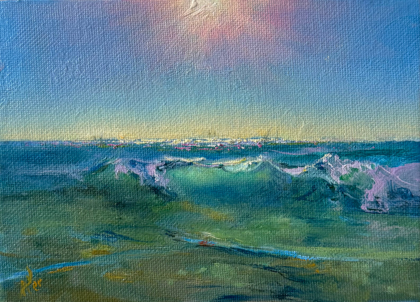 Small geez seascape, showing sunlight, distant sailing boats on the glowing horizon , green sea and clear tidal waters.