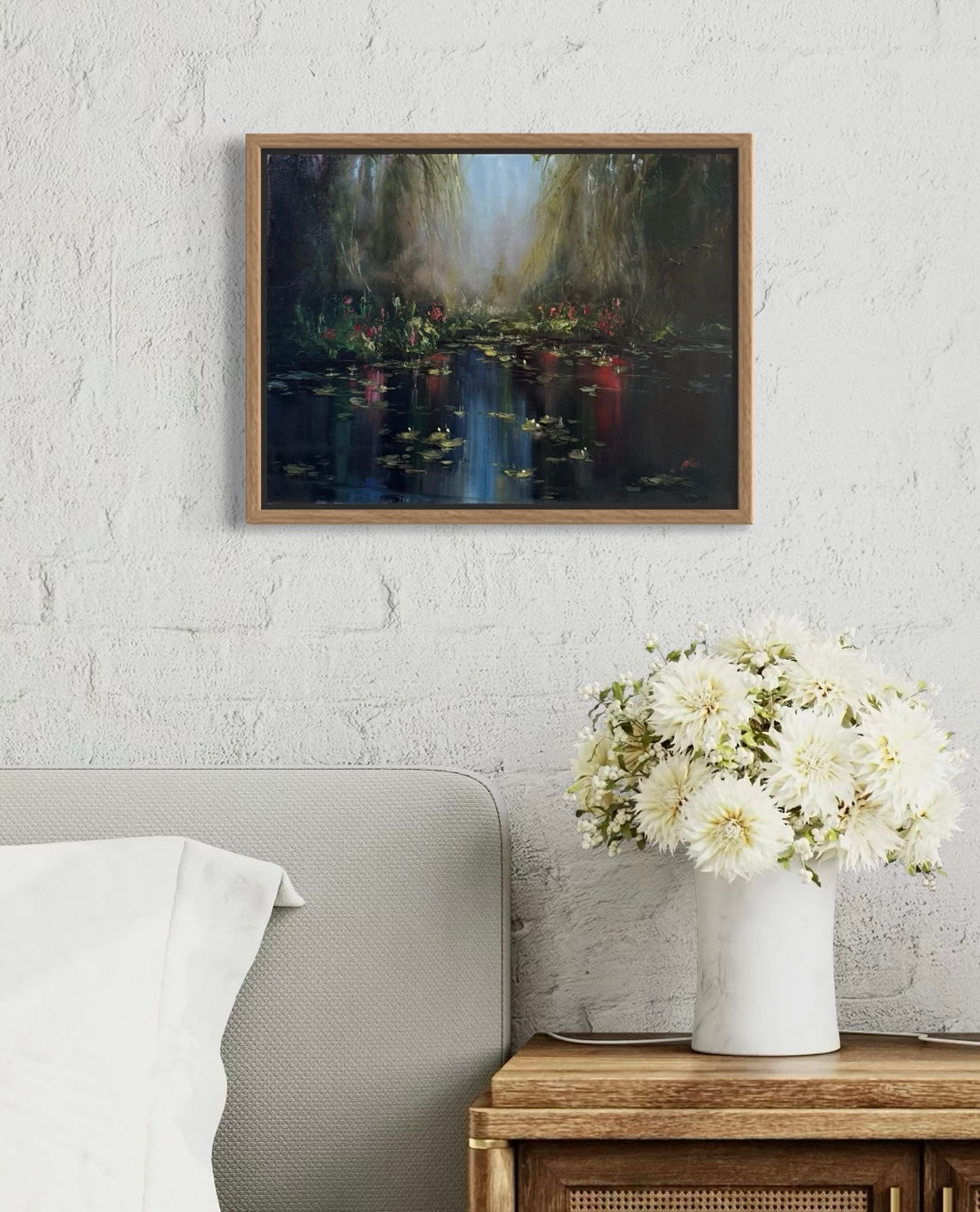 Framed lily pond painting hanging near a bed.