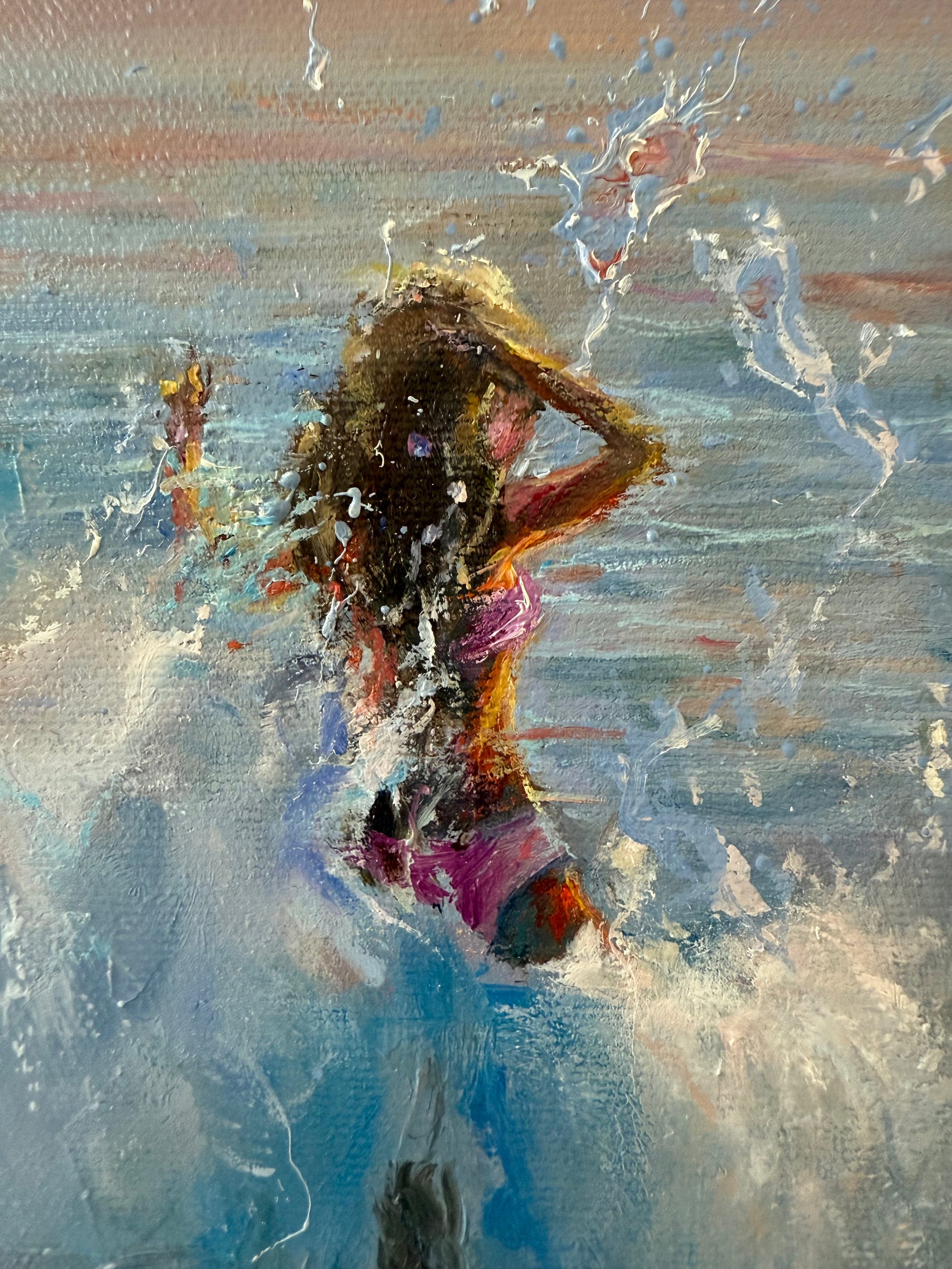 Close up of a seascape , showing a girl in pink bikini, jumping in waves at sunset times.