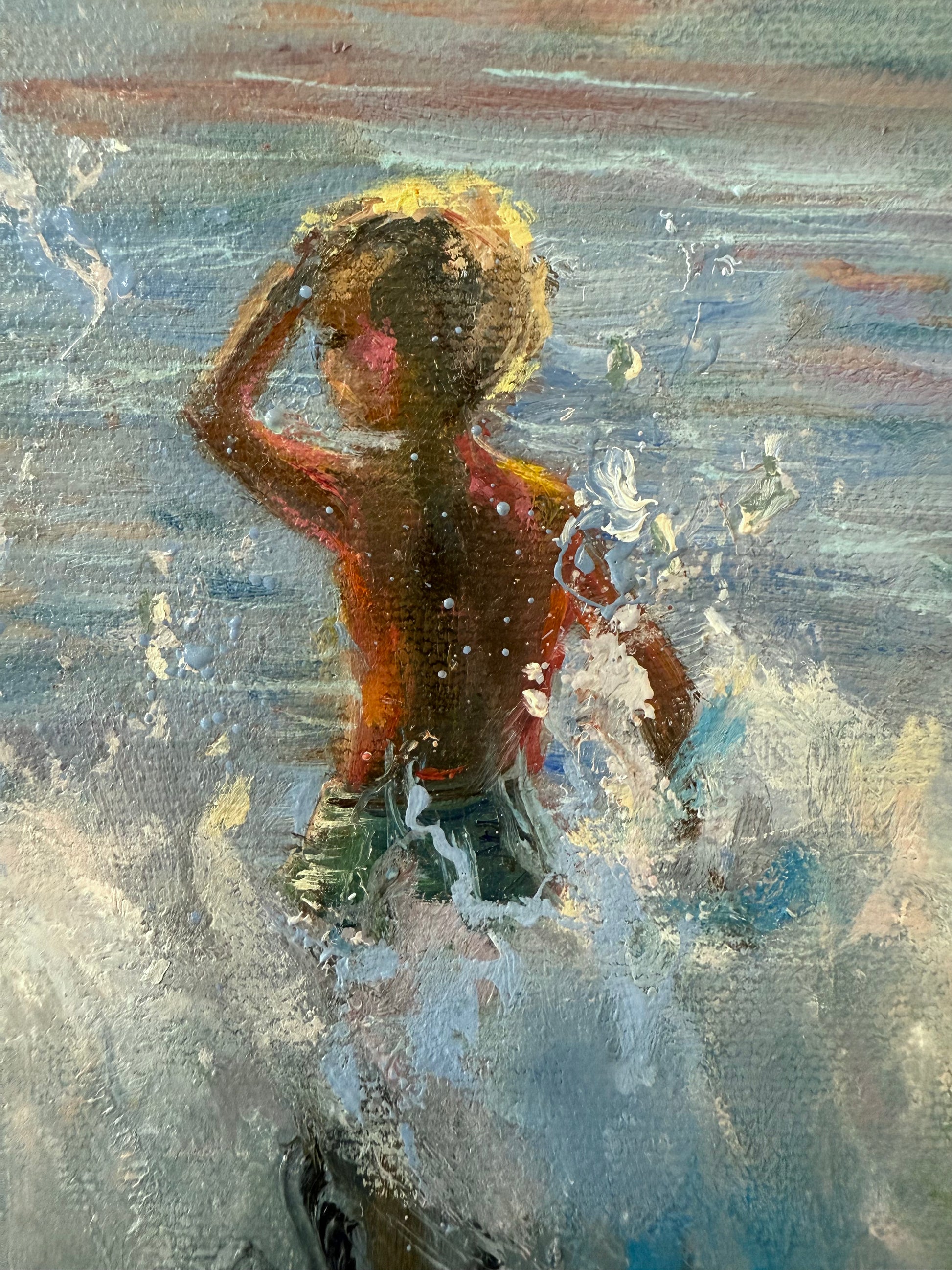 Close up of a boy splashing in the sea waves.