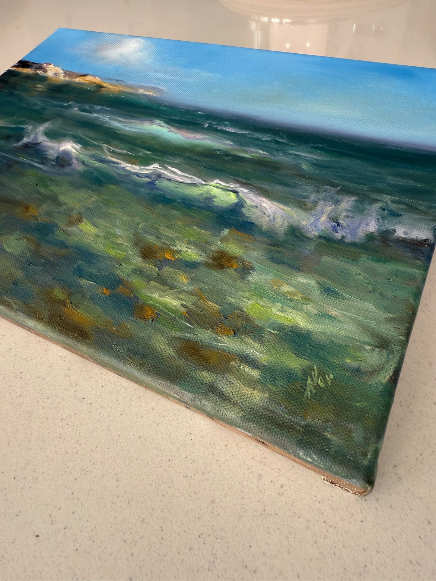 Green seascape on a gallery wrapped canvas, sides painted, featuring clear glowing shallow water and stones at the bottom of the sea.