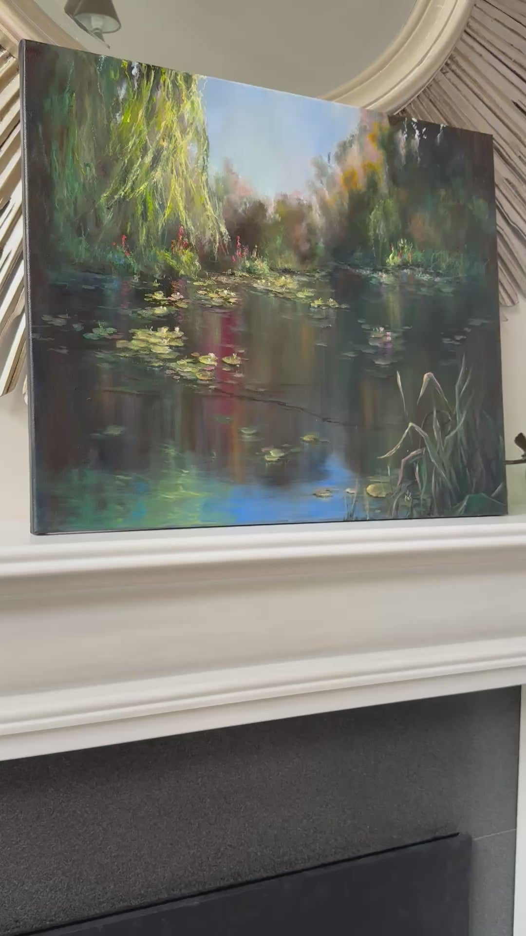 Video of a lily pond painting featuring lilies flowers, lily leaves, blue sky and its reflection on the water, willow trees branches hanging above the pond’s surface.