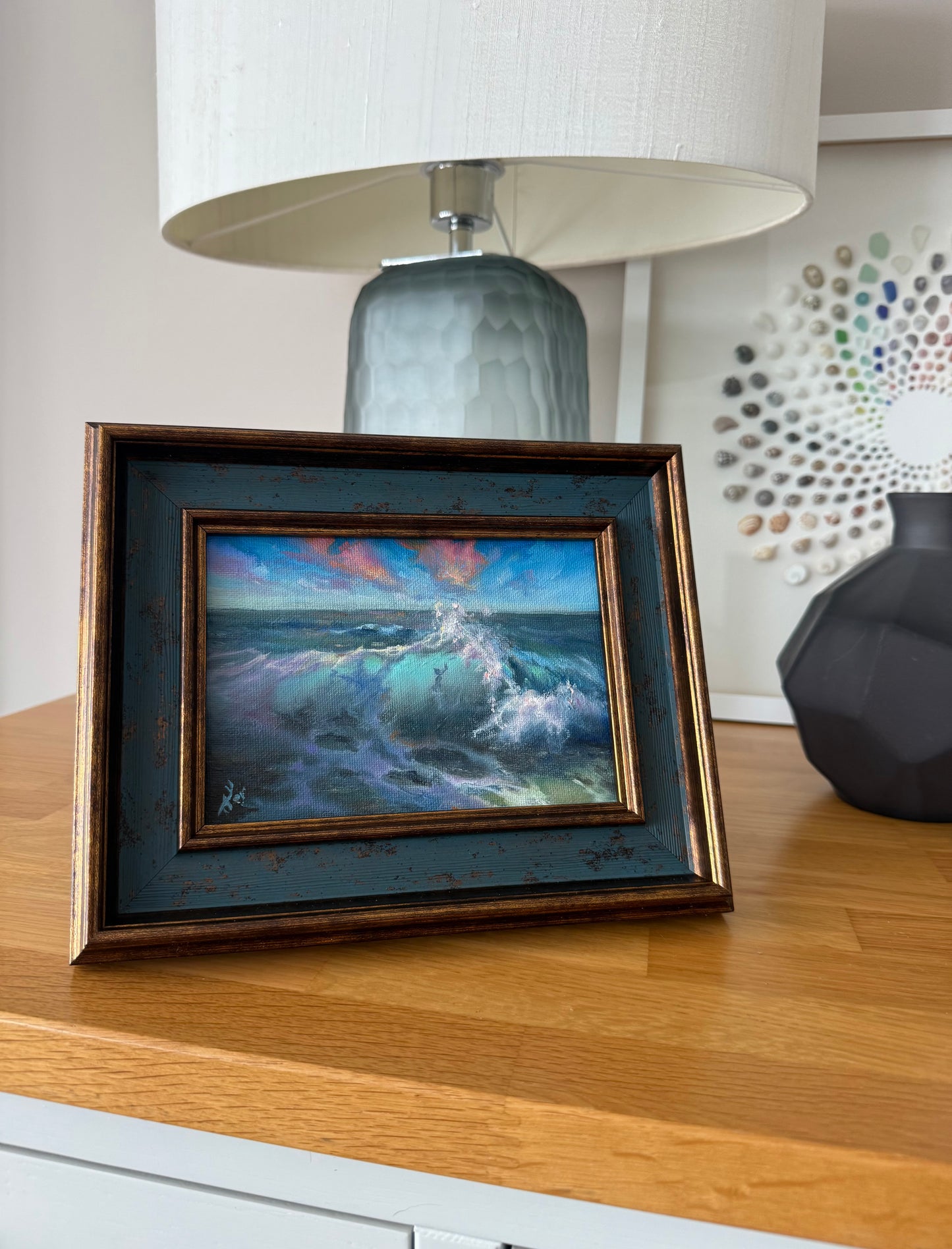 Ocean oil painting in teal and bronze frame.