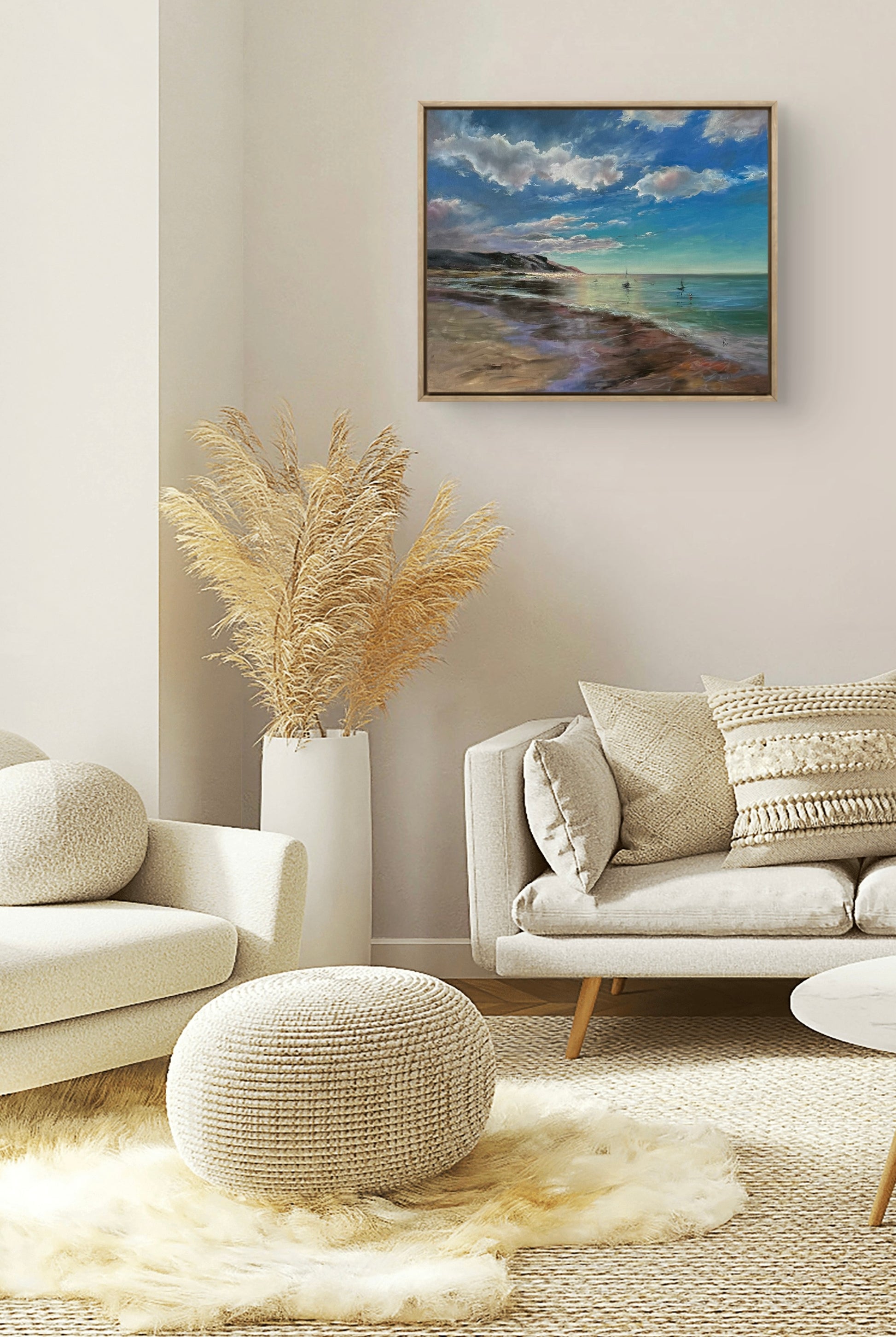 Modern living room with a coastal artwork on the wall, beige sofa, and decorative elements.