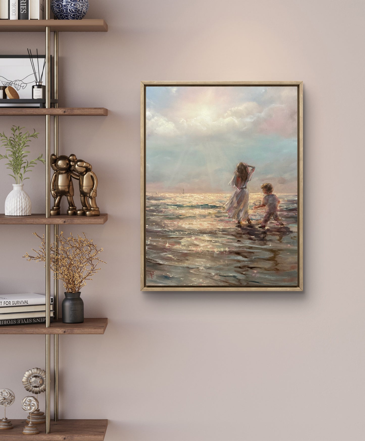 Framed seascape artwork of two children on a beach hanging on a wall above a wooden shelf.
