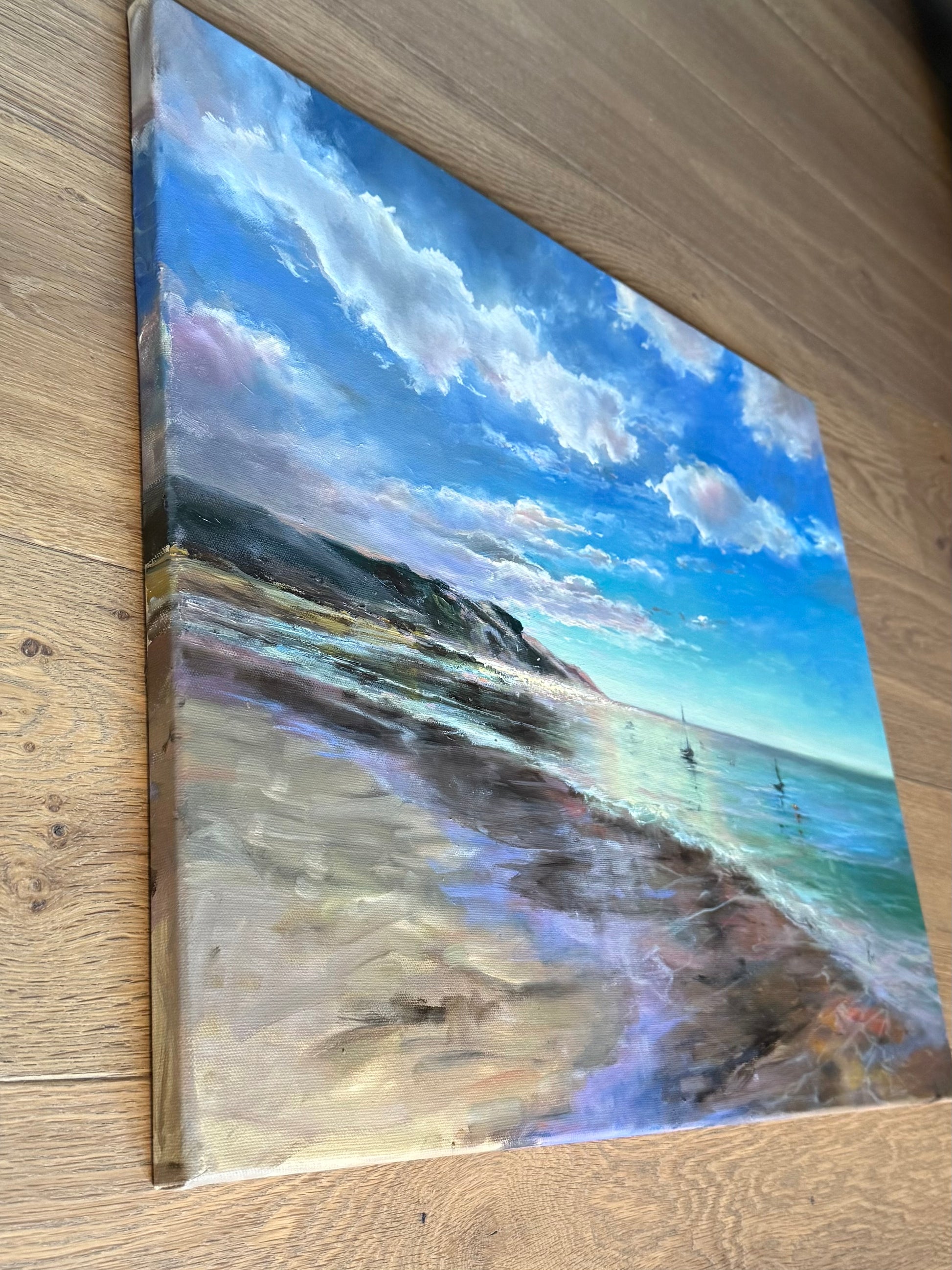 Painting of a beach scene with a blue sky and clouds , sides are painted.