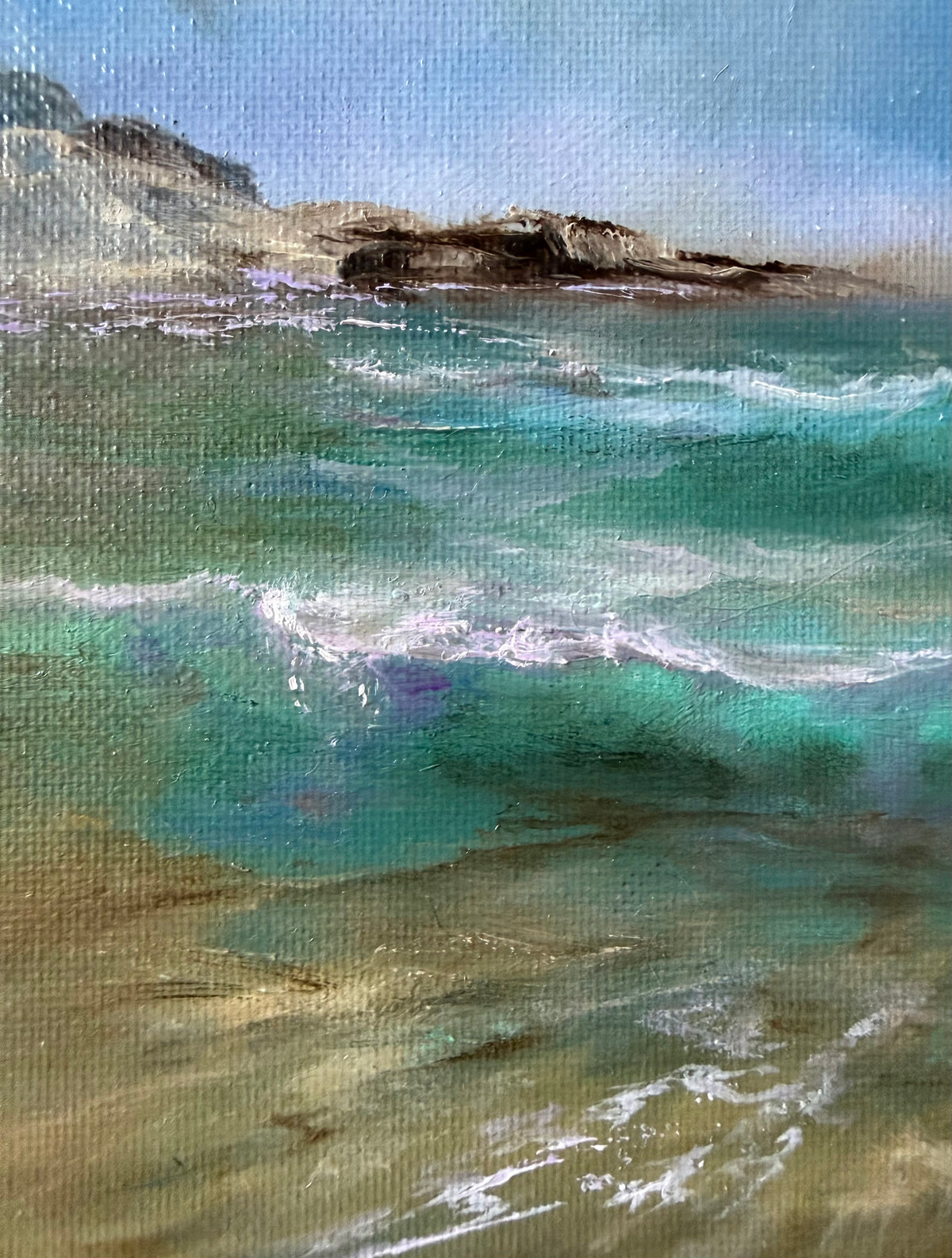 A textured canvas painting of a coastal seascape with turquoise and teal ocean waves, white foam, sandy beige shore, and dark rocky cliffs under a pale blue sky.