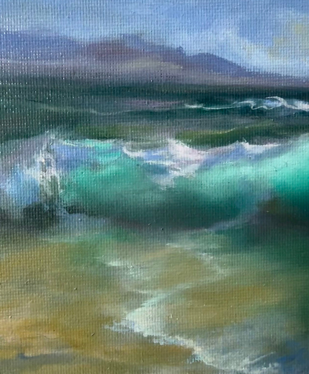 A close-up of an oil painting on canvas depicting a wave crashing onto a sandy shore under a blue sky, with a wooden easel visible at the bottom.