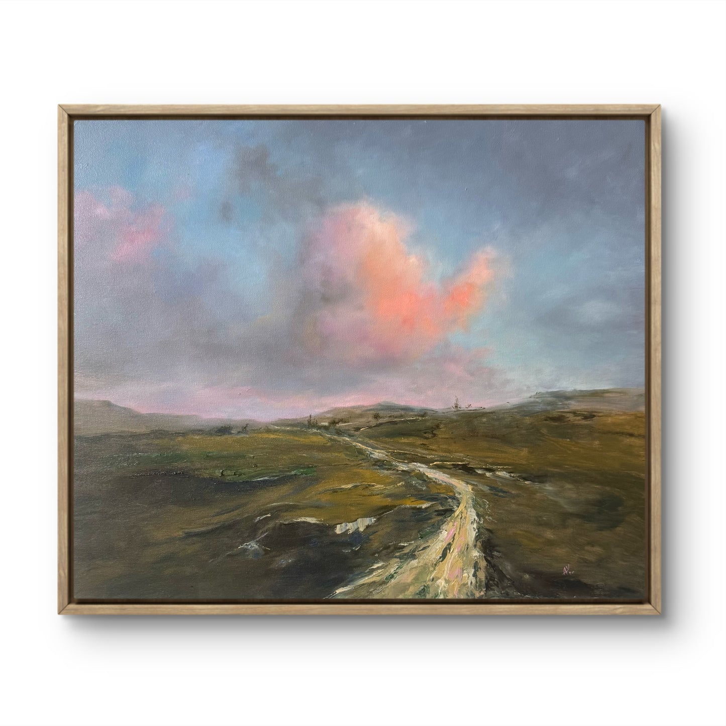 Framed sunset sky and green hills landscape.