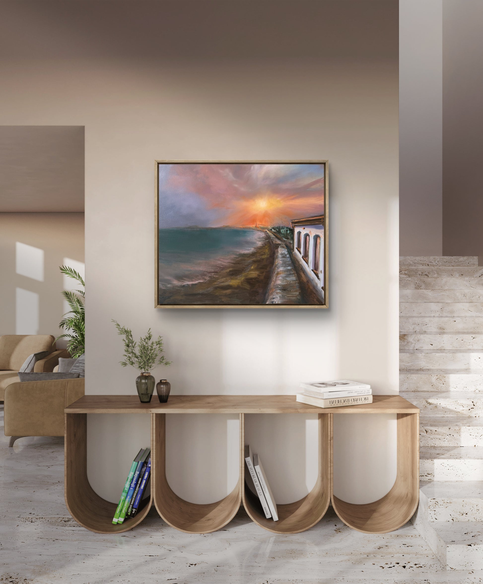 Modern living room with a console table and a painting of a sunset over sea water.