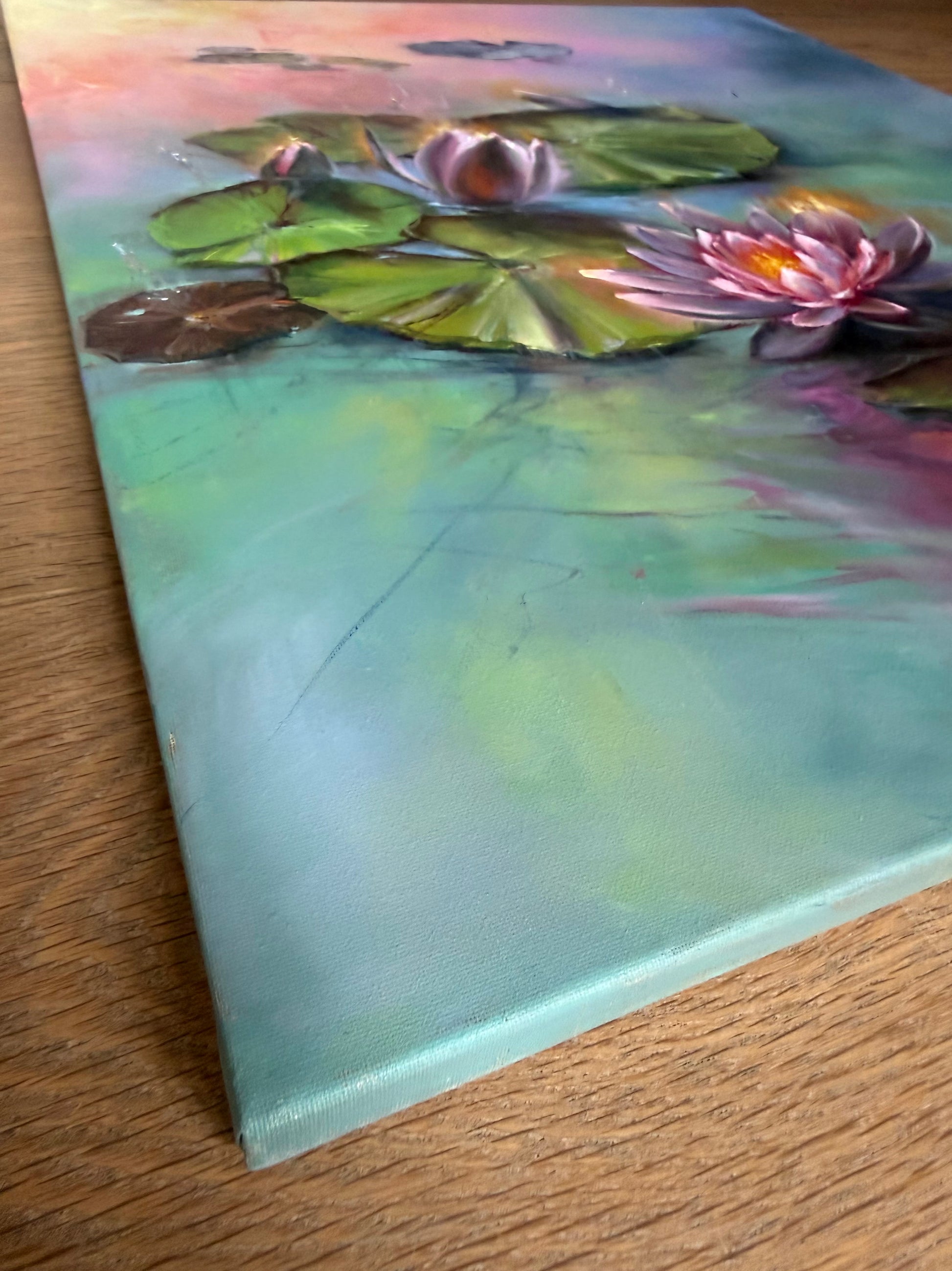 Painting of water lilies on a canvas, painted on sides. The water is teal with sunrise reflections. 