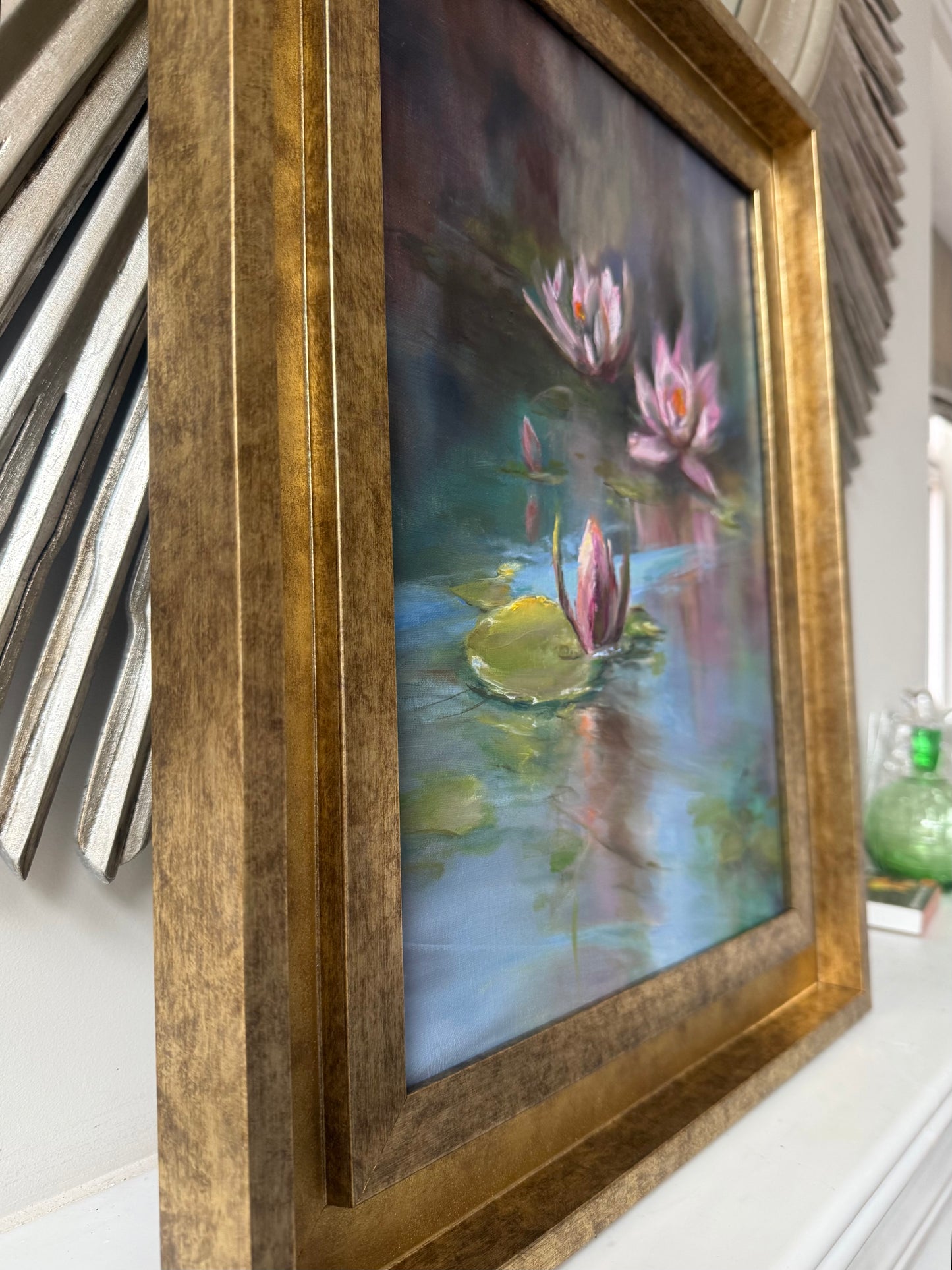 Framed painting of water lilies on a white surface